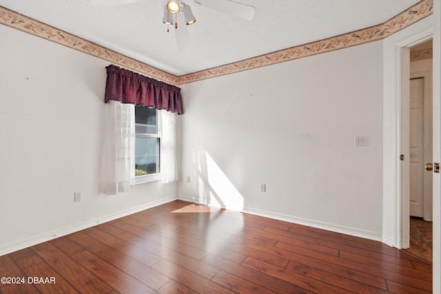 spare room with ceiling fan, a textured ceiling, and dark hardwood / wood-style flooring