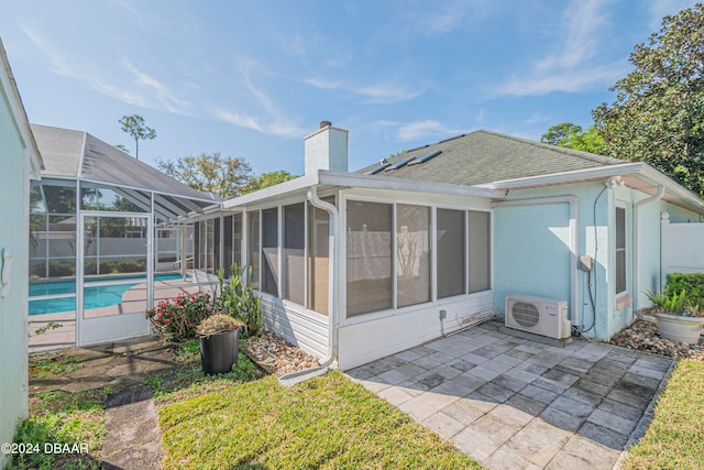 back of property with a patio, a sunroom, glass enclosure, and ac unit