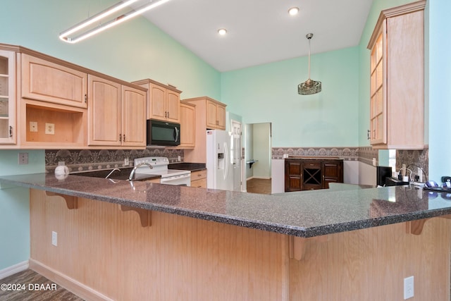 kitchen with light brown cabinetry, kitchen peninsula, white appliances, and wood-type flooring