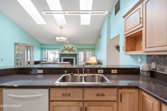 kitchen with light brown cabinets, lofted ceiling, sink, and white dishwasher