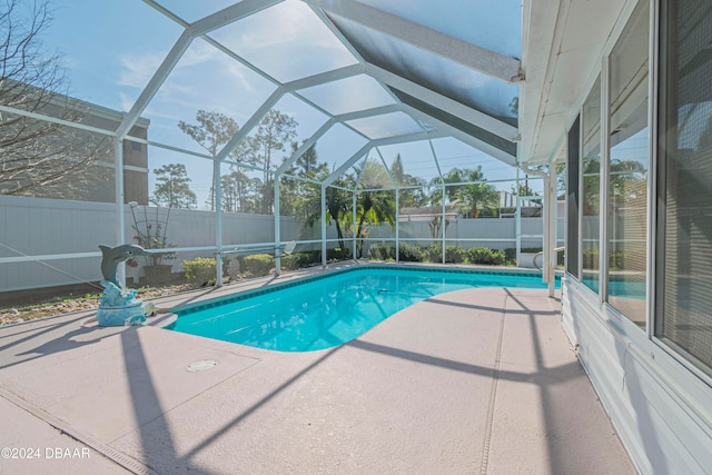 view of swimming pool with glass enclosure and a patio