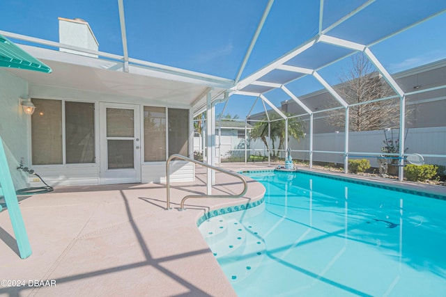 view of swimming pool featuring glass enclosure and a patio area