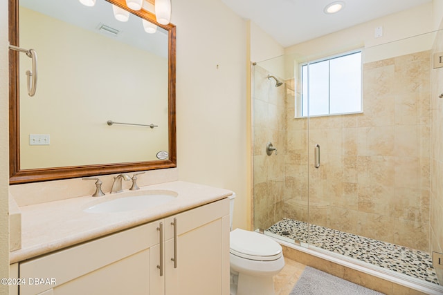 bathroom featuring a shower with door, vanity, toilet, and tile patterned flooring