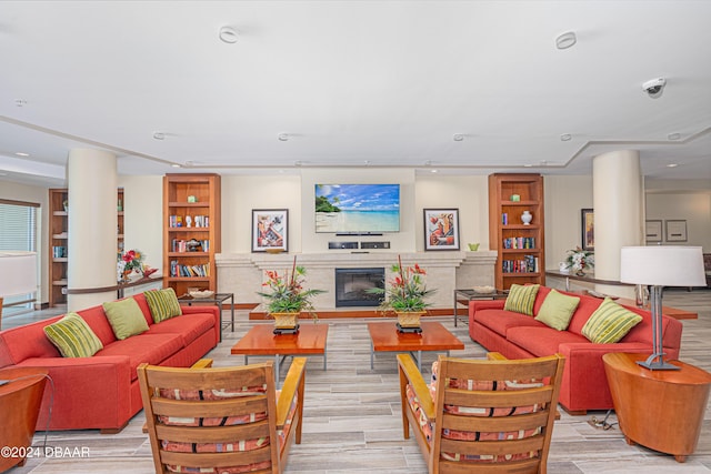 1925 S Atlantic Ave Unit 806, Daytona Beach Shores, FL 32118 - living area featuring a glass covered fireplace, light wood-type flooring, and decorative columns