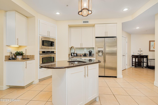 1925 S Atlantic Ave Unit 806, Daytona Beach Shores, FL 32118 - kitchen with appliances with stainless steel finishes, a sink, dark stone counters, light tile patterned flooring, and white cabinetry