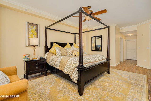 bedroom featuring ornamental molding, light wood-type flooring, and ceiling fan