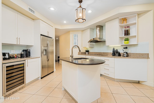 kitchen featuring stainless steel fridge with ice dispenser, sink, beverage cooler, wall chimney exhaust hood, and a kitchen island with sink