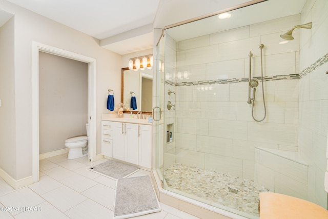 bathroom with toilet, vanity, tile patterned floors, and a shower with door