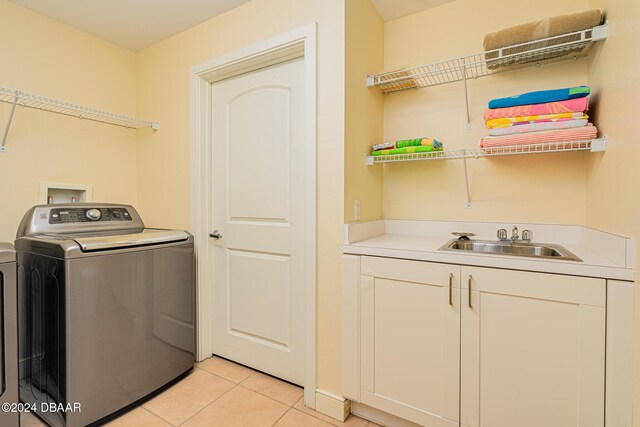 1925 S Atlantic Ave Unit 806, Daytona Beach Shores, FL 32118 - washroom with washer / dryer, cabinet space, and light tile patterned flooring
