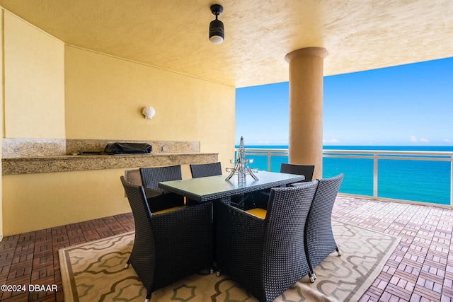 view of patio with a balcony and a water view