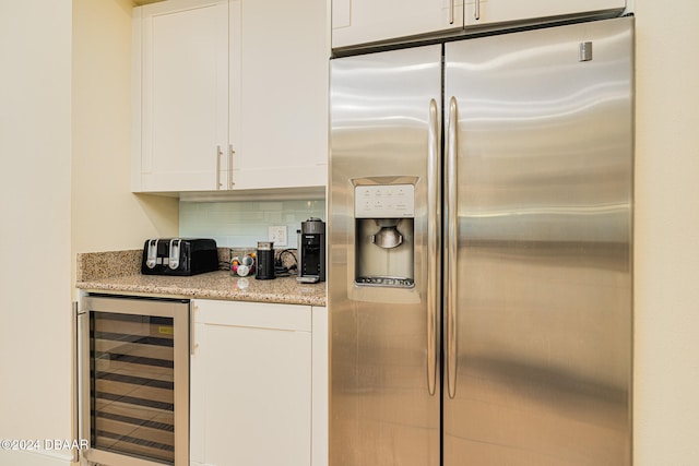 kitchen featuring white cabinets, tasteful backsplash, stainless steel fridge with ice dispenser, and wine cooler