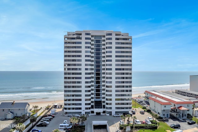 view of building exterior with a water view and a view of the beach