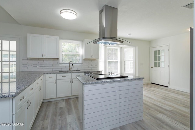 640 Old Treeline Trl, Deland, FL 32724 - kitchen featuring a sink, island range hood, black electric stovetop, light wood-style flooring, and decorative backsplash