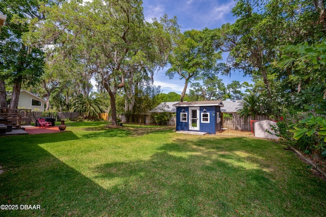 view of yard featuring an outbuilding, a shed, and a fenced backyard