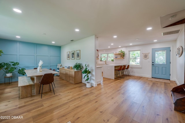 interior space with recessed lighting, a decorative wall, plenty of natural light, and light wood-style floors