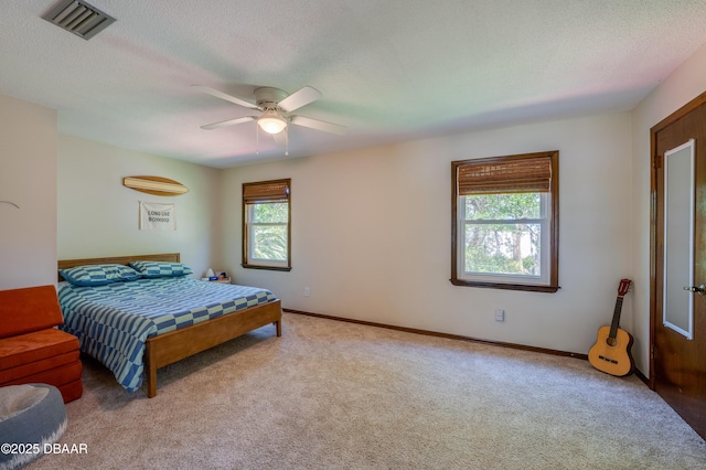 bedroom featuring a textured ceiling, carpet, visible vents, a ceiling fan, and baseboards