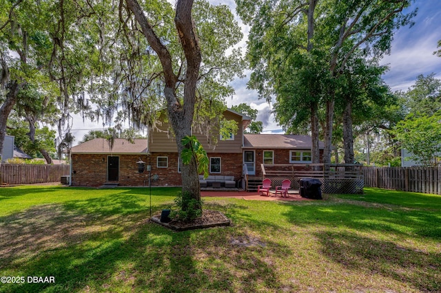 back of property featuring a fenced backyard, a patio, a yard, and brick siding