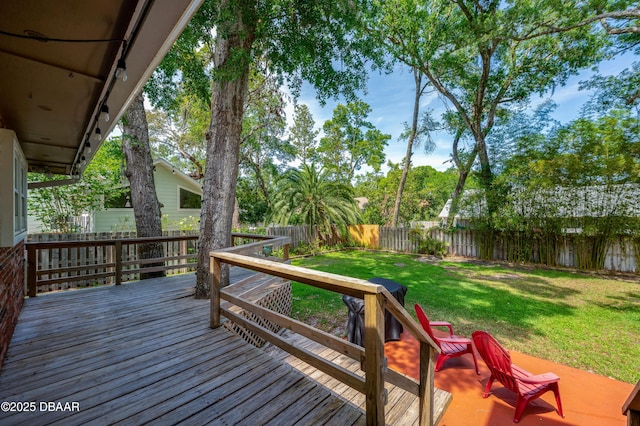 wooden terrace with a lawn and a fenced backyard