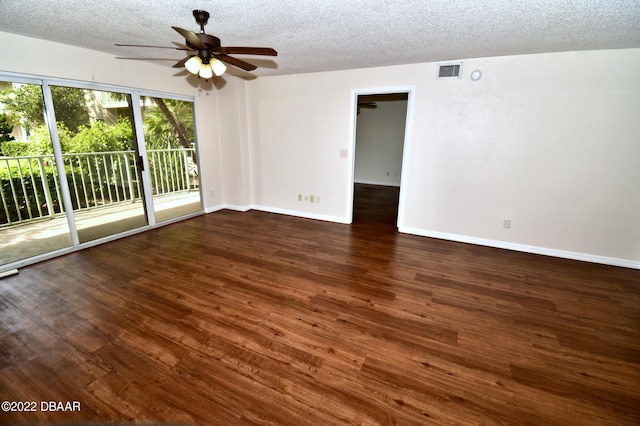 empty room with dark hardwood / wood-style floors and a textured ceiling