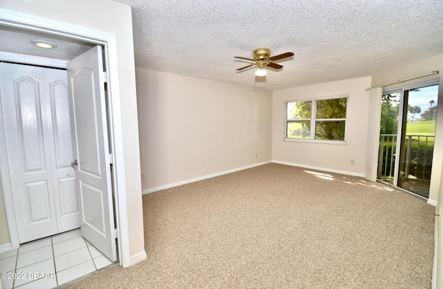 carpeted empty room with a textured ceiling and ceiling fan