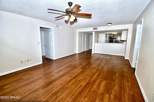 unfurnished living room with a textured ceiling, dark wood-type flooring, and ceiling fan with notable chandelier