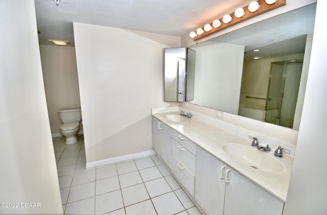 bathroom with tile patterned floors, a shower with door, vanity, and toilet