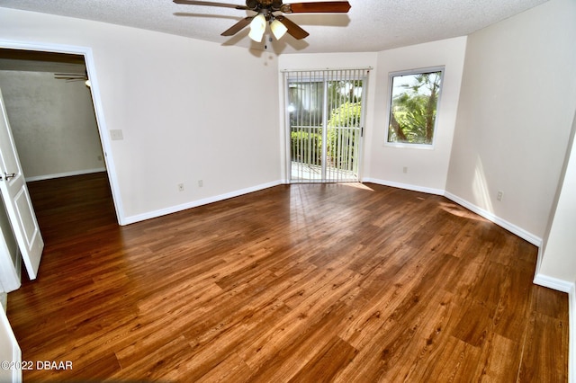 spare room featuring dark hardwood / wood-style floors, ceiling fan, and a textured ceiling