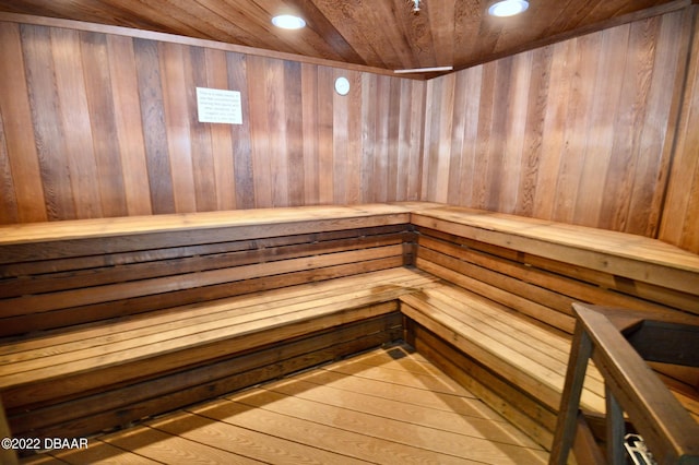 view of sauna with wood walls, wood-type flooring, and wood ceiling