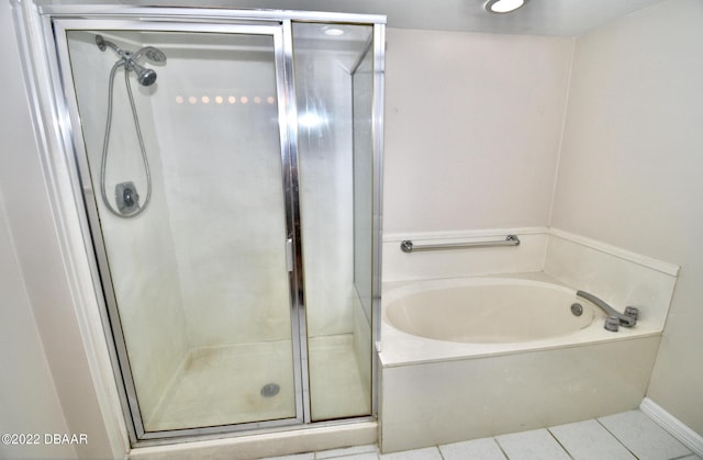 bathroom featuring tile patterned floors and separate shower and tub