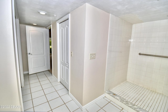 bathroom featuring tile patterned floors, a textured ceiling, and tiled shower