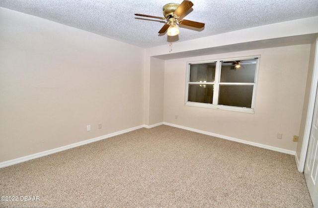 carpeted spare room featuring a textured ceiling and ceiling fan