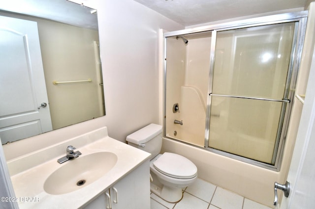 full bathroom featuring tile patterned floors, toilet, vanity, and combined bath / shower with glass door