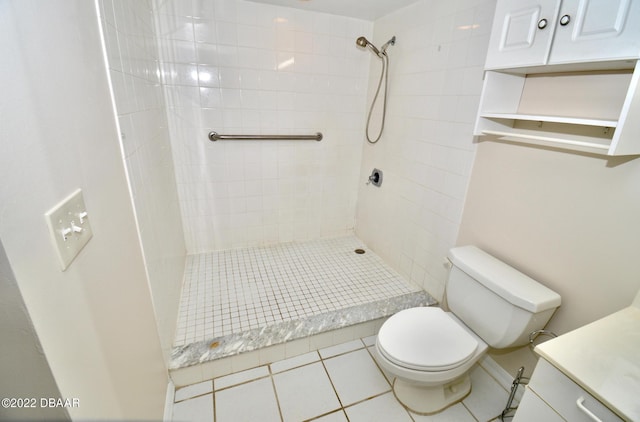 bathroom featuring tile patterned flooring, tiled shower, and toilet