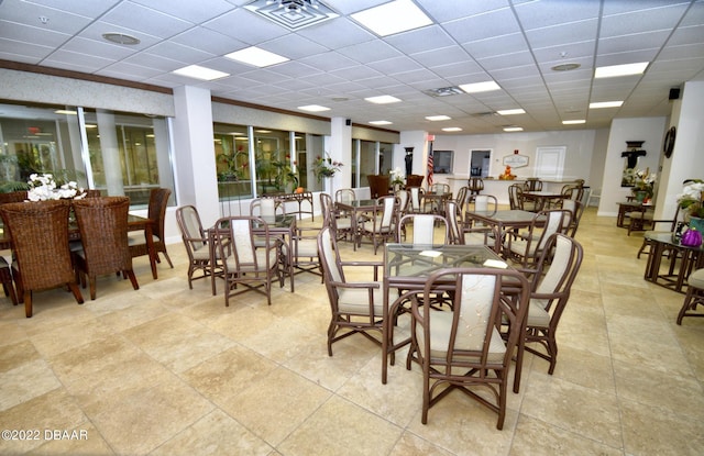 dining room with a drop ceiling and light tile patterned flooring