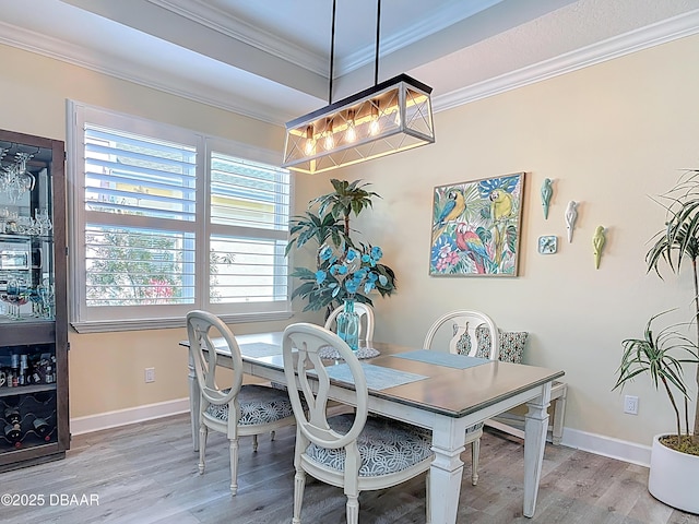 dining area with crown molding, wood finished floors, and baseboards