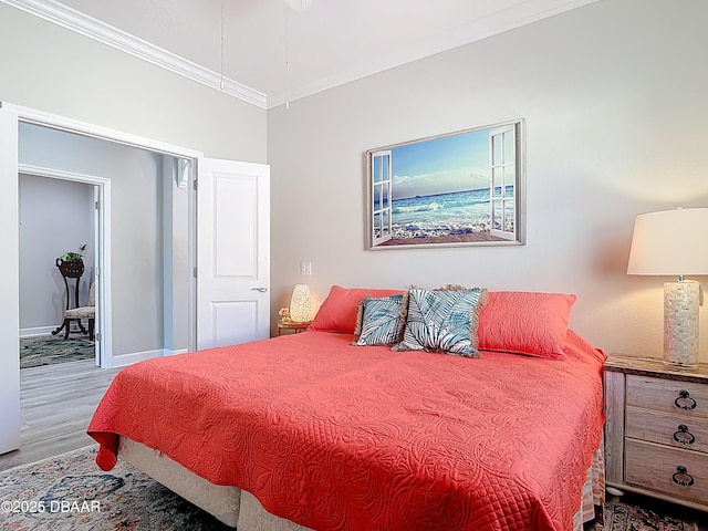 bedroom with baseboards, wood finished floors, and crown molding