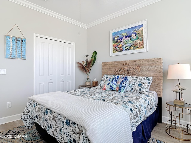 bedroom featuring a closet, crown molding, baseboards, and wood finished floors