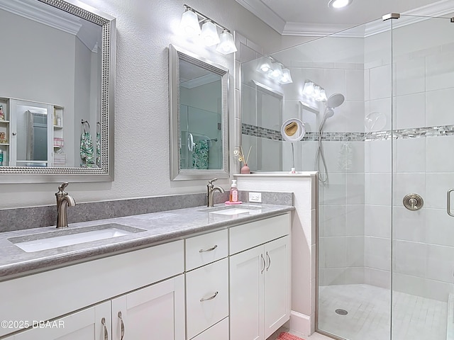 full bathroom featuring double vanity, ornamental molding, a shower stall, and a sink