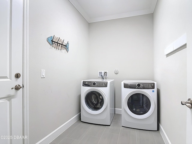 washroom featuring laundry area, ornamental molding, baseboards, and washing machine and clothes dryer