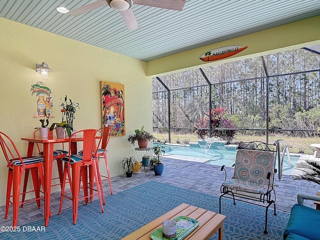 view of patio with a lanai, an outdoor pool, and a ceiling fan