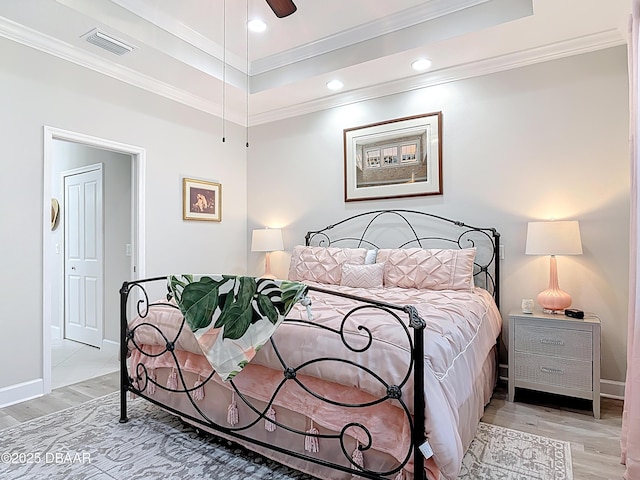 bedroom with visible vents, light wood-style flooring, and crown molding