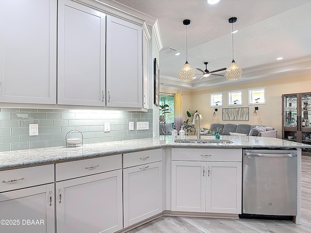 kitchen featuring visible vents, a sink, a peninsula, dishwasher, and ceiling fan