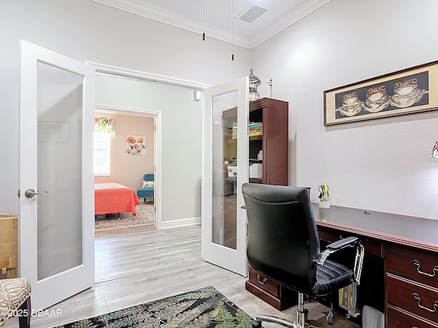 office featuring baseboards, visible vents, french doors, crown molding, and light wood-type flooring