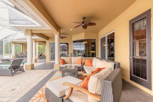 view of patio / terrace with an outdoor living space, glass enclosure, and ceiling fan