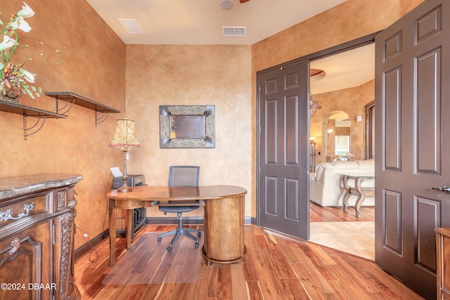 home office with light hardwood / wood-style flooring