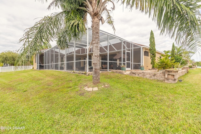 back of house featuring a yard and a lanai