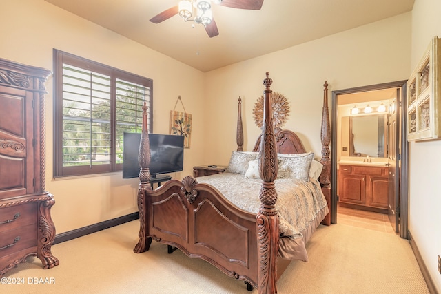 bedroom featuring ceiling fan, light colored carpet, sink, and connected bathroom