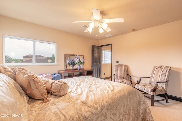 bedroom with multiple windows, ceiling fan, and carpet floors