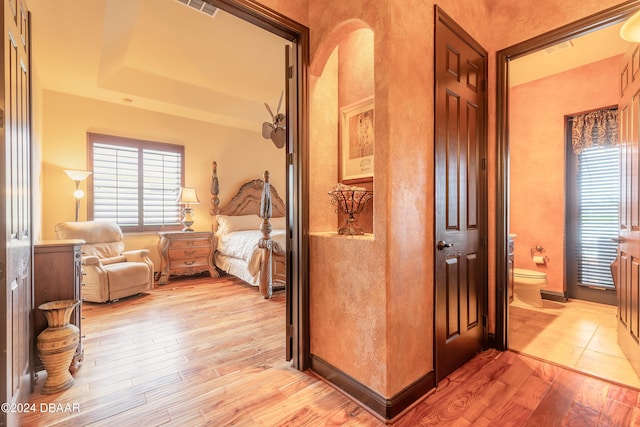 bedroom featuring light hardwood / wood-style floors and ensuite bathroom