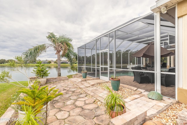 view of patio / terrace with a water view and glass enclosure